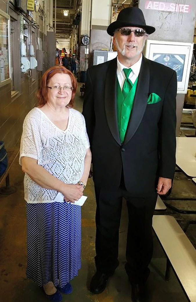 Mark and his wife at his retirement party. “It was common for most men to wear a suit on their final day,” he said of his BN green accessories.  